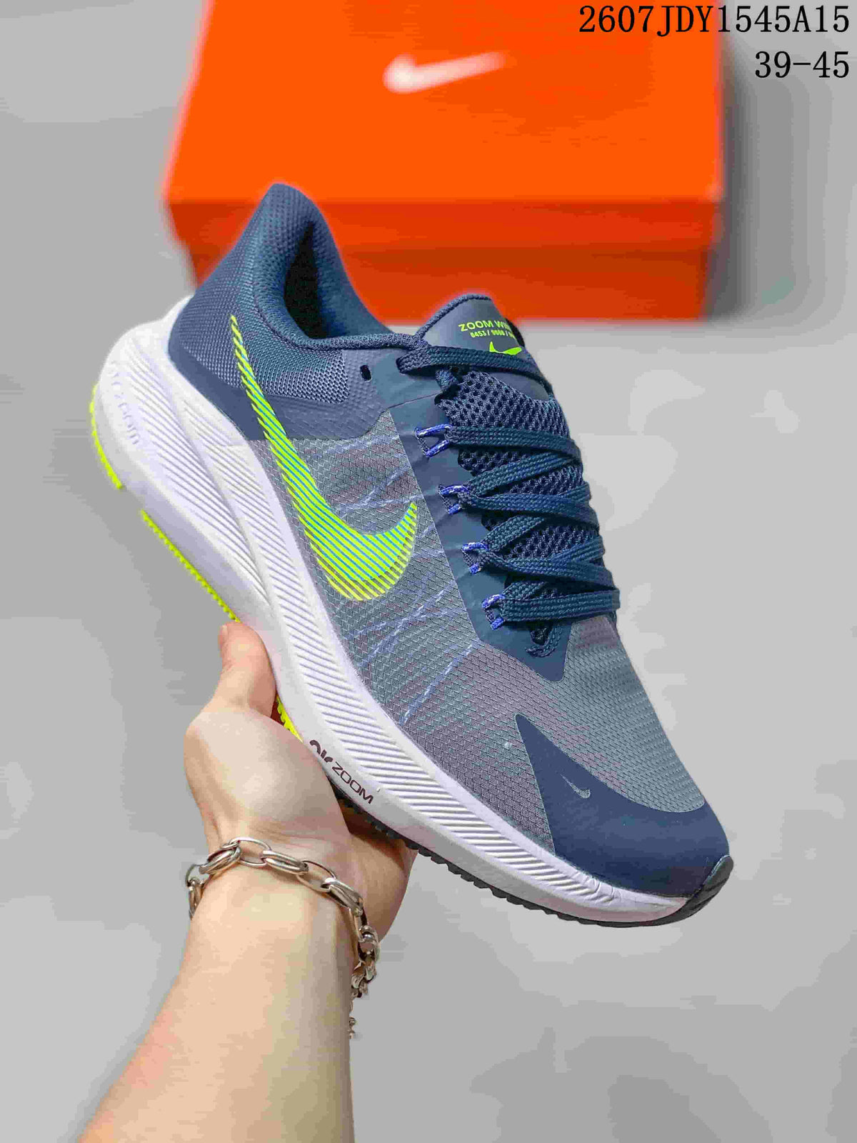 Angled side view of a gray and navy Nike Zoom Winflo 8 running shoe with lime green Swoosh detailing and a white midsole.