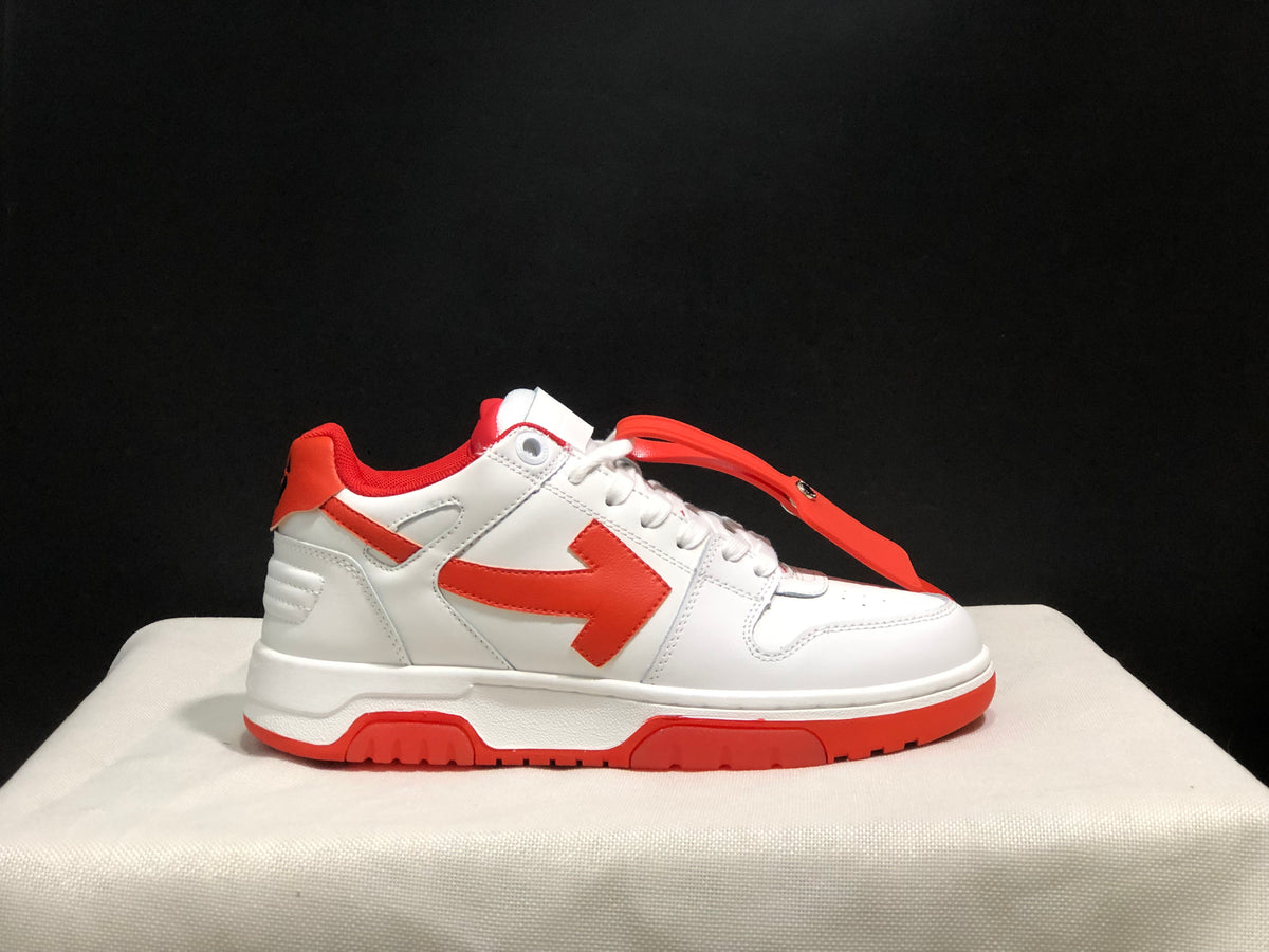 Side profile of a single white and red sneaker with a red accessory strap across the upper.
