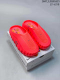 Bright red Nike Mind 001 slides displayed on a branded box, showing the perforated upper, textured footbed and thick scalloped sole.