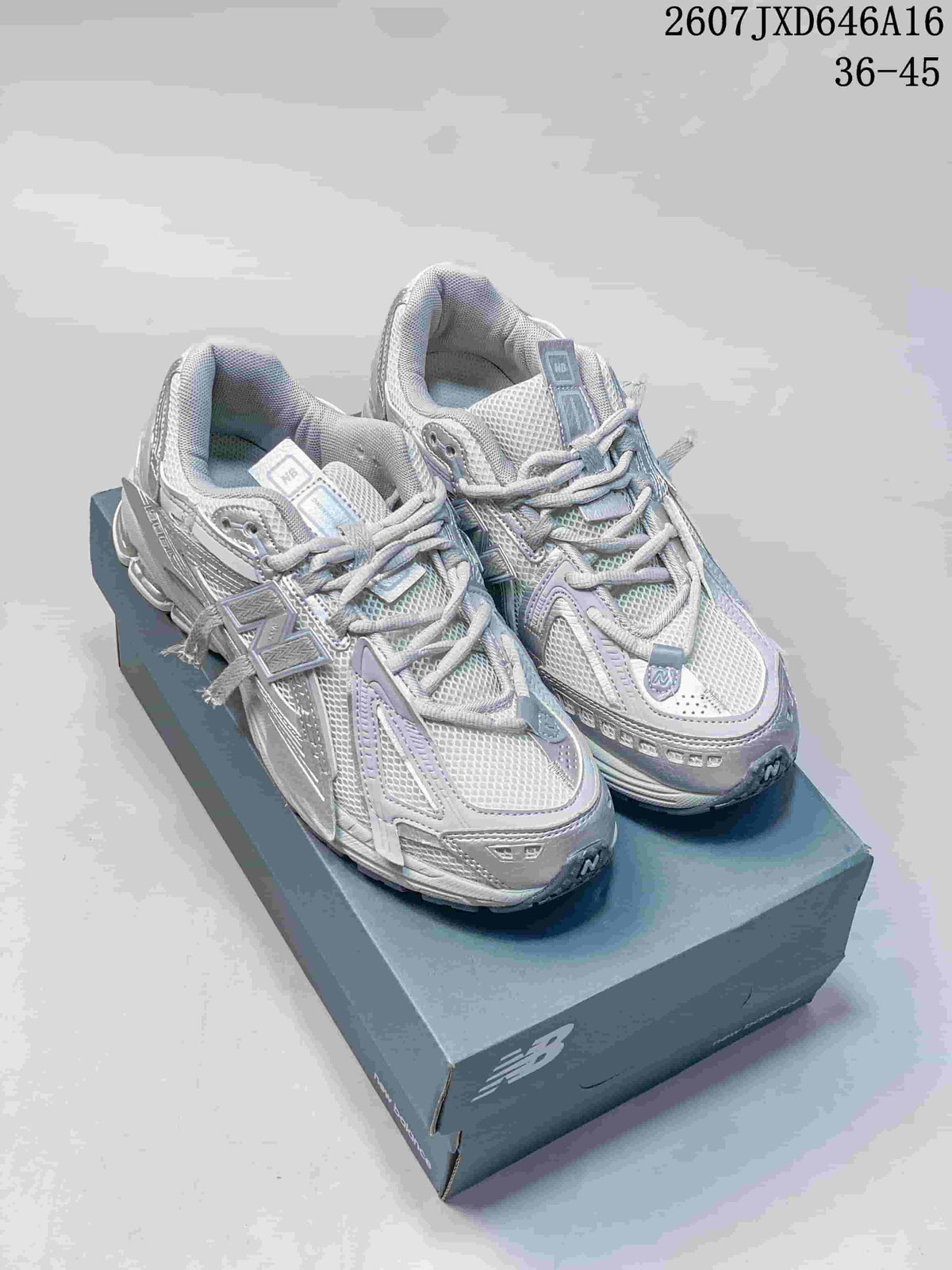 Pair of light gray and white New Balance 1906A sneakers displayed on a shoebox.