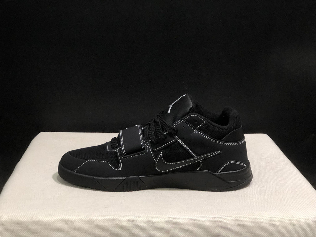 Lateral profile of one black sneaker showing the Swoosh, strap, contrast stitching and sculpted sole.