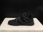 Lateral profile of one black sneaker showing the Swoosh, strap, contrast stitching and sculpted sole.