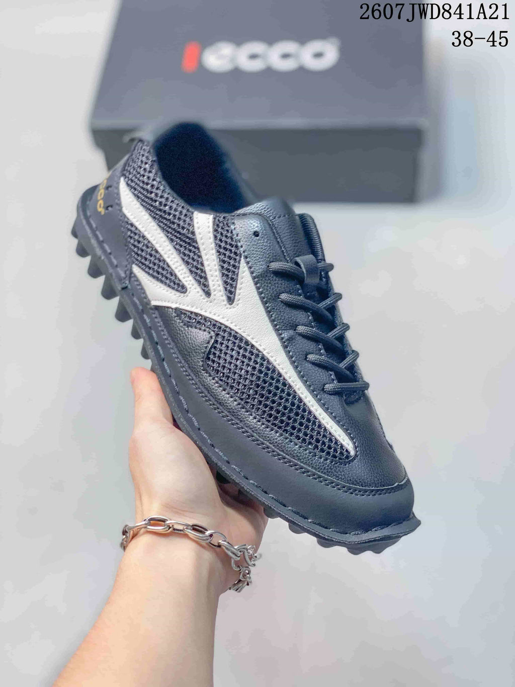 Angled side view of the black and white ECCO sneaker showing the lace-up upper, mesh panels and textured outsole.
