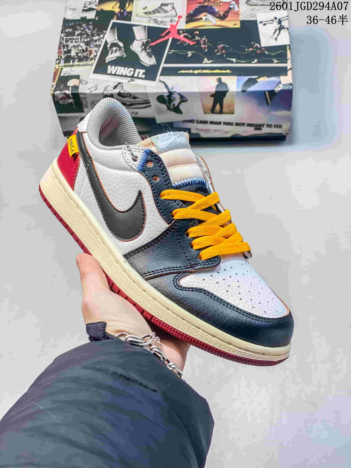 Close view of a white, dark, and red low-top sneaker with yellow laces