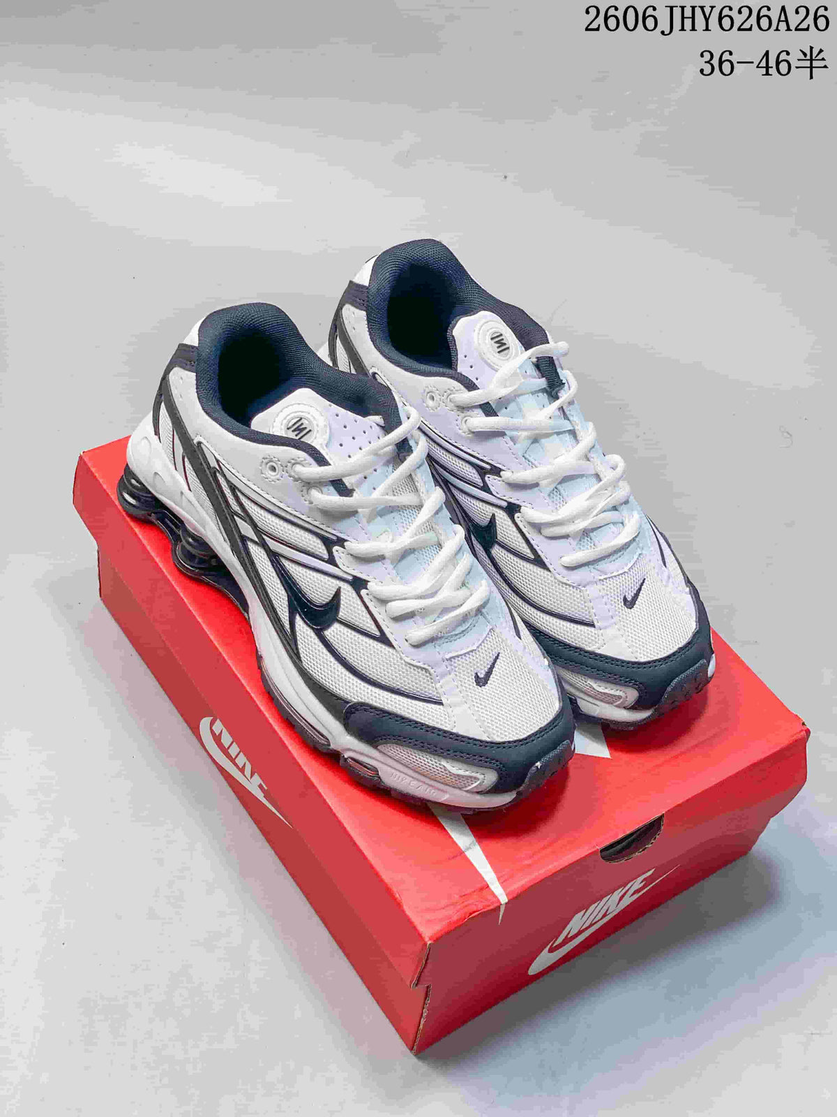 Pair of white and dark gray Nike Shox Ride 2 sneakers shown on a red shoe box