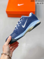 Side view of a navy and white Nike Vapor 12 tennis shoe showing the lace structure, side detailing, and outsole.