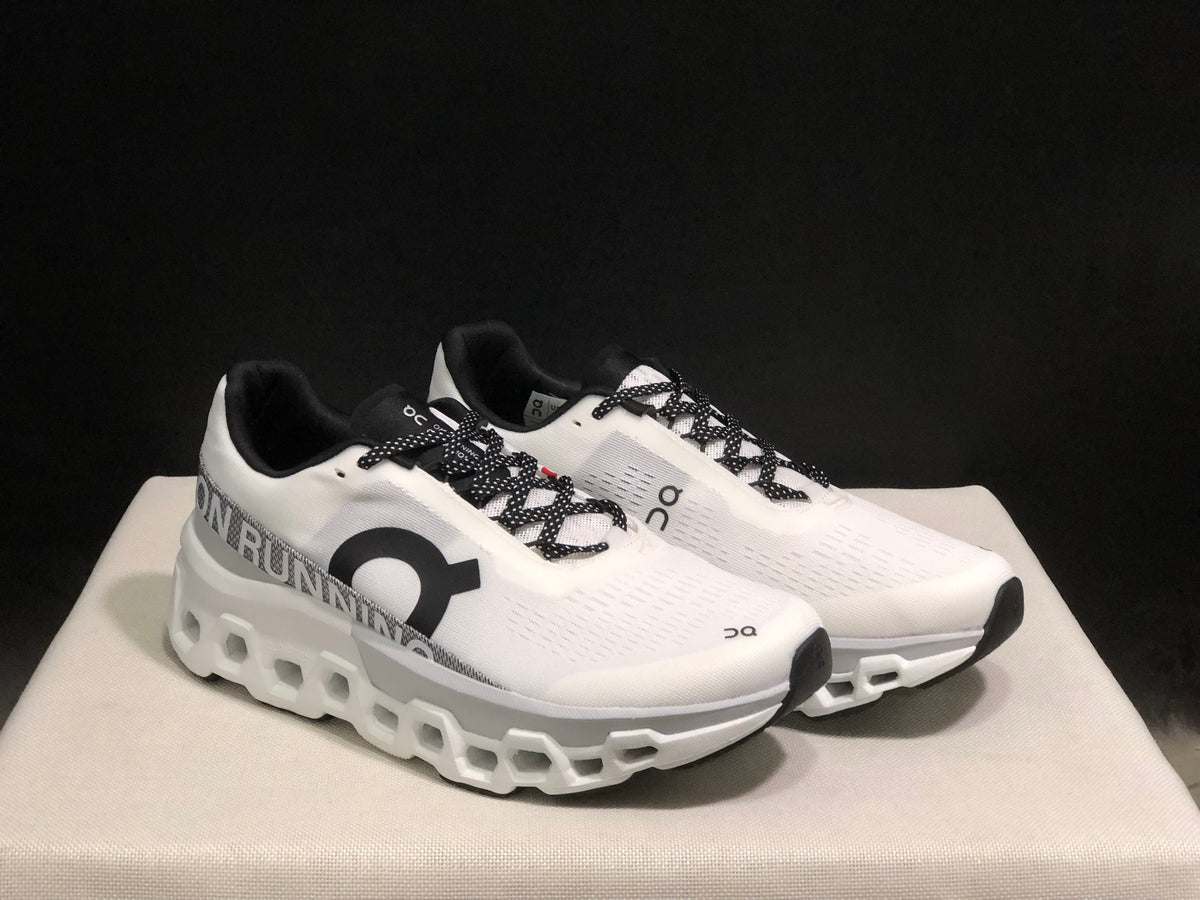 Pair of white On Cloudmonster 2 shoes shown from an angled front view