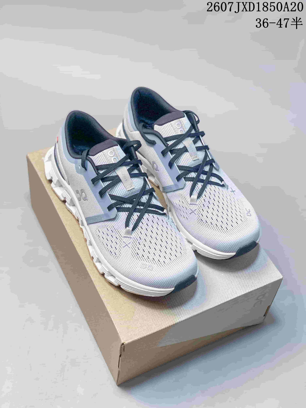 White On Cloud X 4 sneakers shown as a pair on a shoebox.