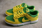 Pair of green and yellow low-top sneakers shown from a front three-quarter angle.