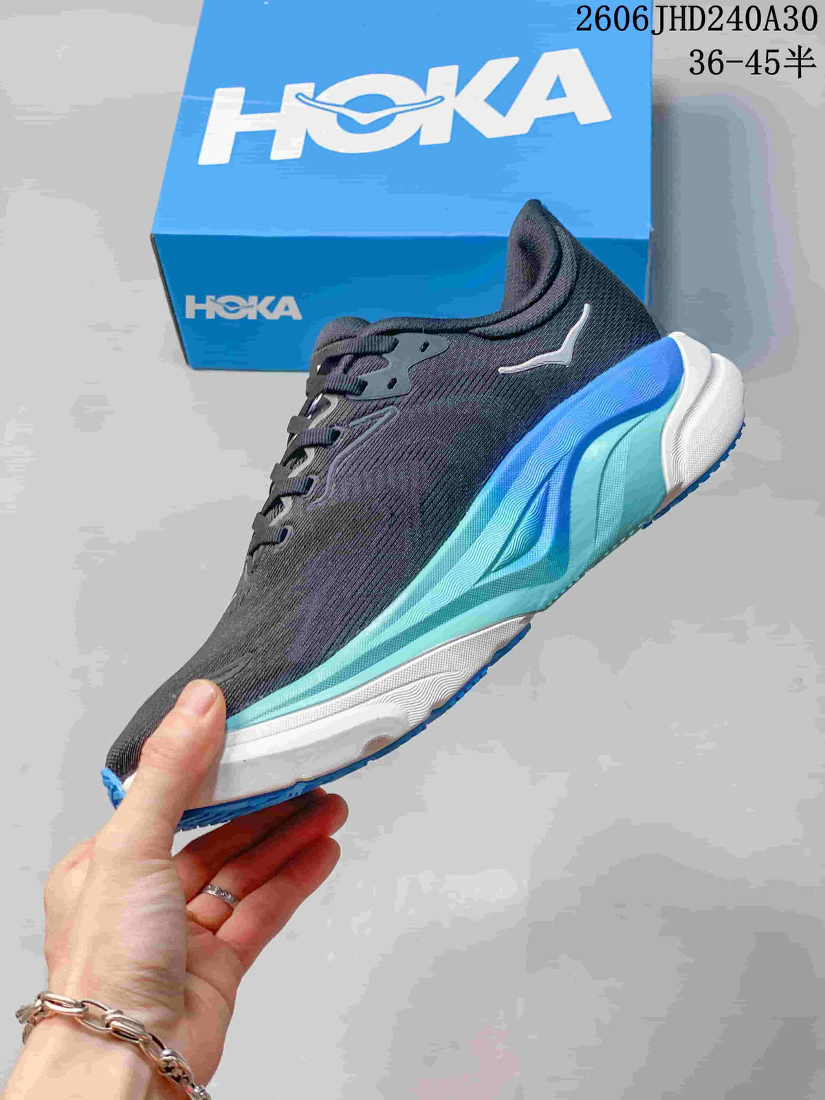 Side view of a charcoal HOKA Arahi 8 running shoe with blue and aqua accents.