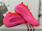 Angled view of the pink and orange Adidas basketball shoes