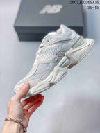 Side profile of a light white New Balance 9060 sneaker showing layered panels, mesh sections and a raised segmented sole.