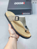 Angled view of a beige buckle sandal with a textured footbed and black outsole.