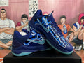 Pair of navy and blue Nike Kobe basketball shoes shown at an angle, with aqua-colored outsoles