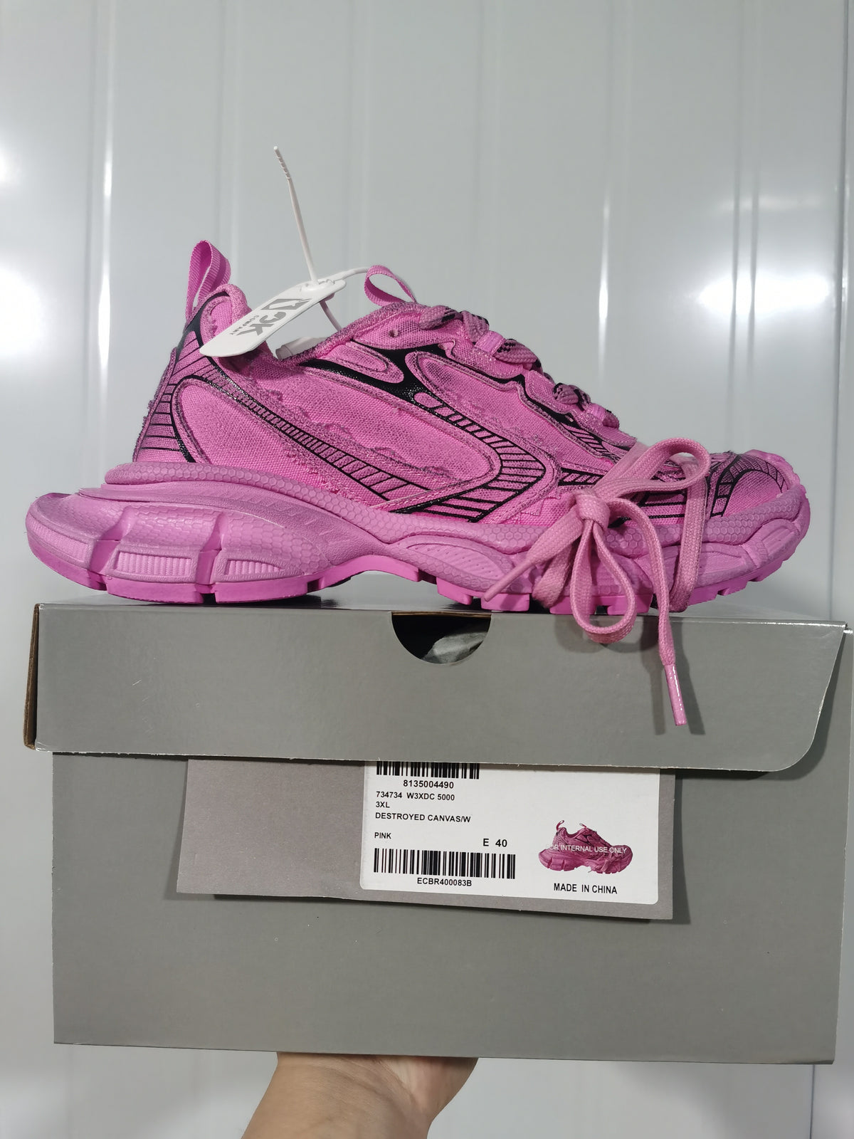 Pink Nike sneaker displayed above its box; the visible box label shows style 734734 W3DC 5000, color pink, and EU 40.