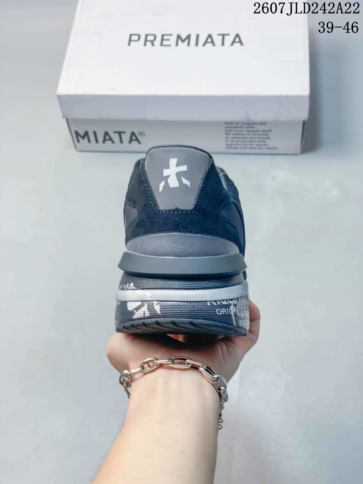 Rear view of the trainers showing the heel branding and layered dark gray sole.