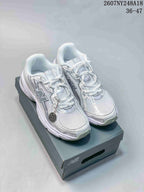 White and silver New Balance 740 sneakers displayed on a shoebox from a front three-quarter angle.
