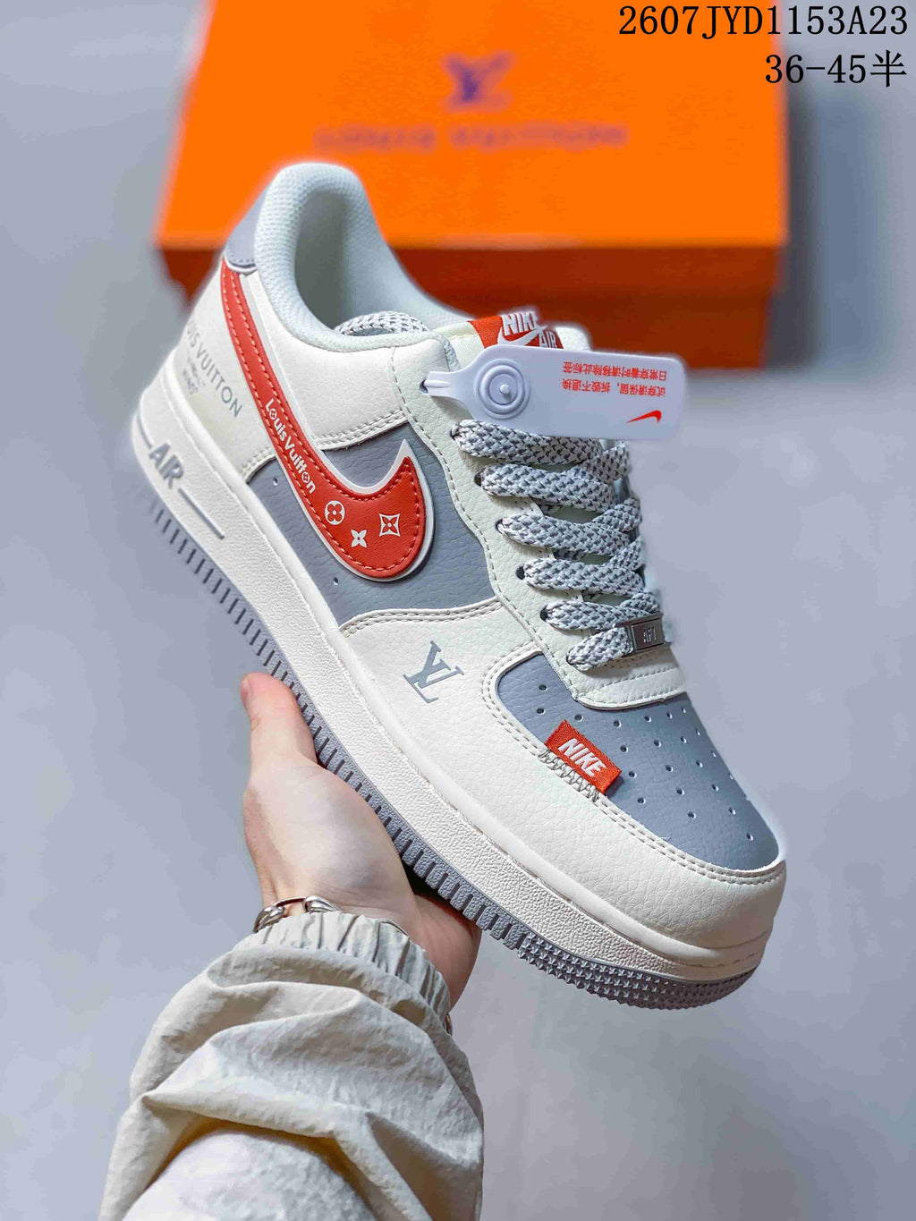 Angled side view showing the white and grey sneaker, red side accent, decorative printed details, laces, and thick sole.