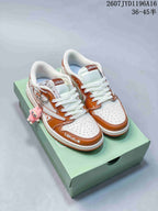 Pair of white and brown low-top Jordan sneakers with Labubu details displayed on a green shoebox.