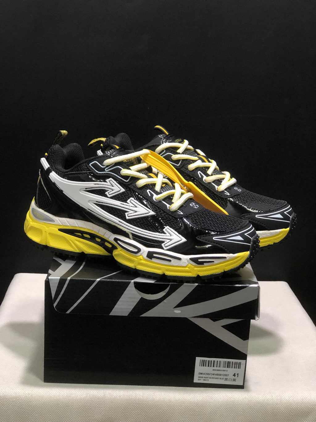 Pair of black, white, and yellow Off-White Be Right Back sneakers displayed on a branded box.