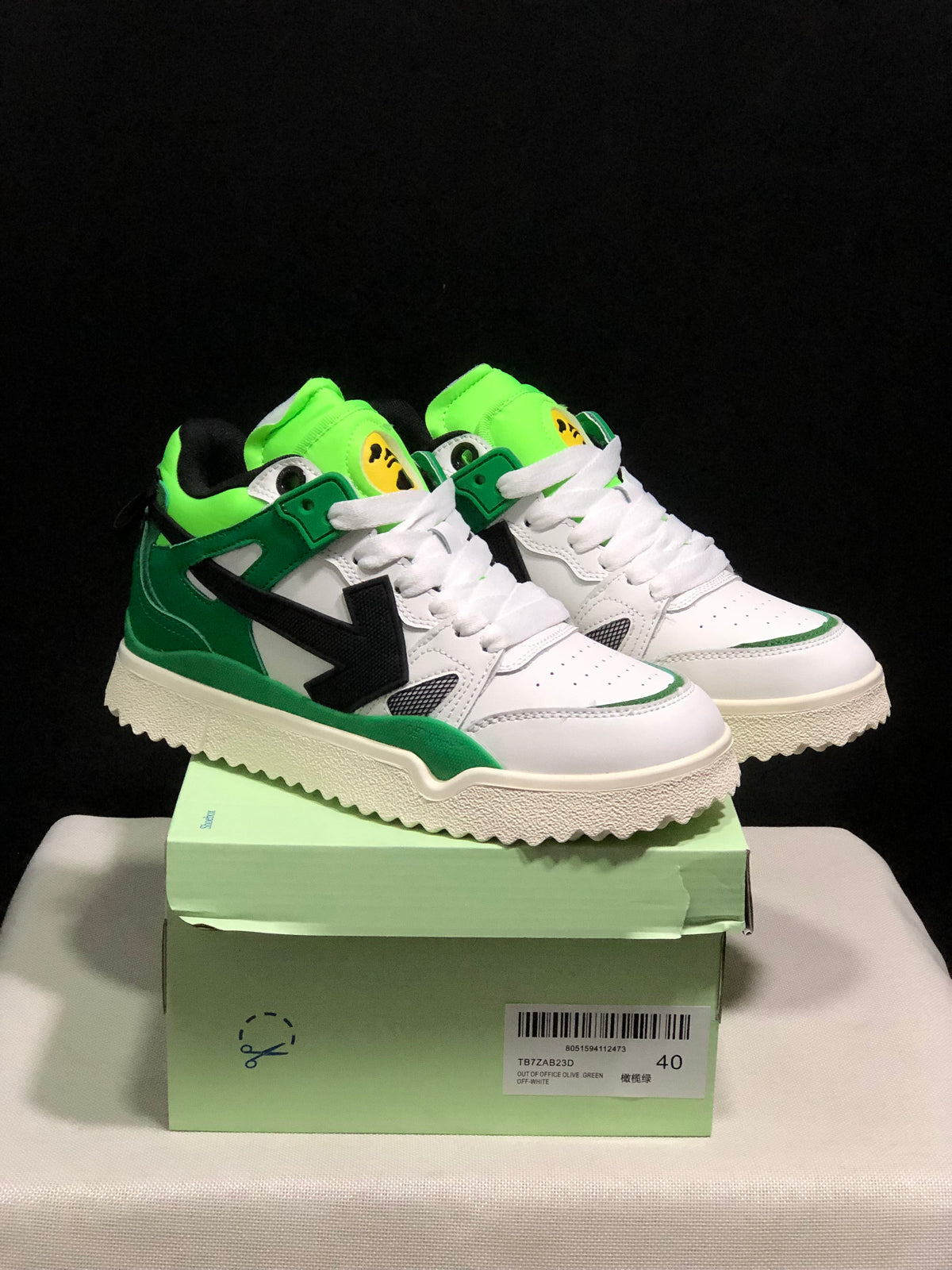 Pair of white, green, and black Off-White sneakers displayed on a green shoe box; the box label shows size 40 and identifies the Out Of Office Olive Green model.