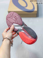 Bottom view of the burgundy tennis shoe showing the patterned rubber outsole and contrasting red, black, and silver sections.