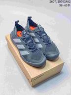 Three Adidas Terrex Daroga 25 shoes in light grey, pale green, and dark grey, shown from the side; image text lists sizes 38–45 and code JD762A02.