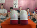 Rear view of white Nike running shoes with pink heel details and purple-toned soles