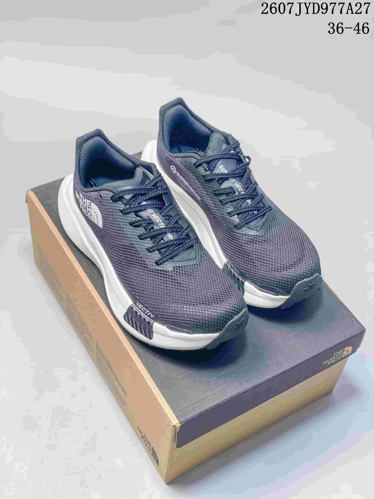 Pair of dark gray and navy The North Face Summit Vectiv Pro trail running shoes displayed on a shoebox.