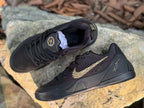Top and side view of black Kobe 9 shoes with signature heel details.