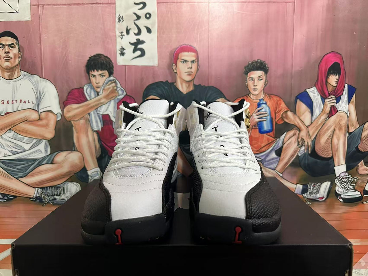 Front view of white and black Jordan 12 sneakers with white laces and red accents.