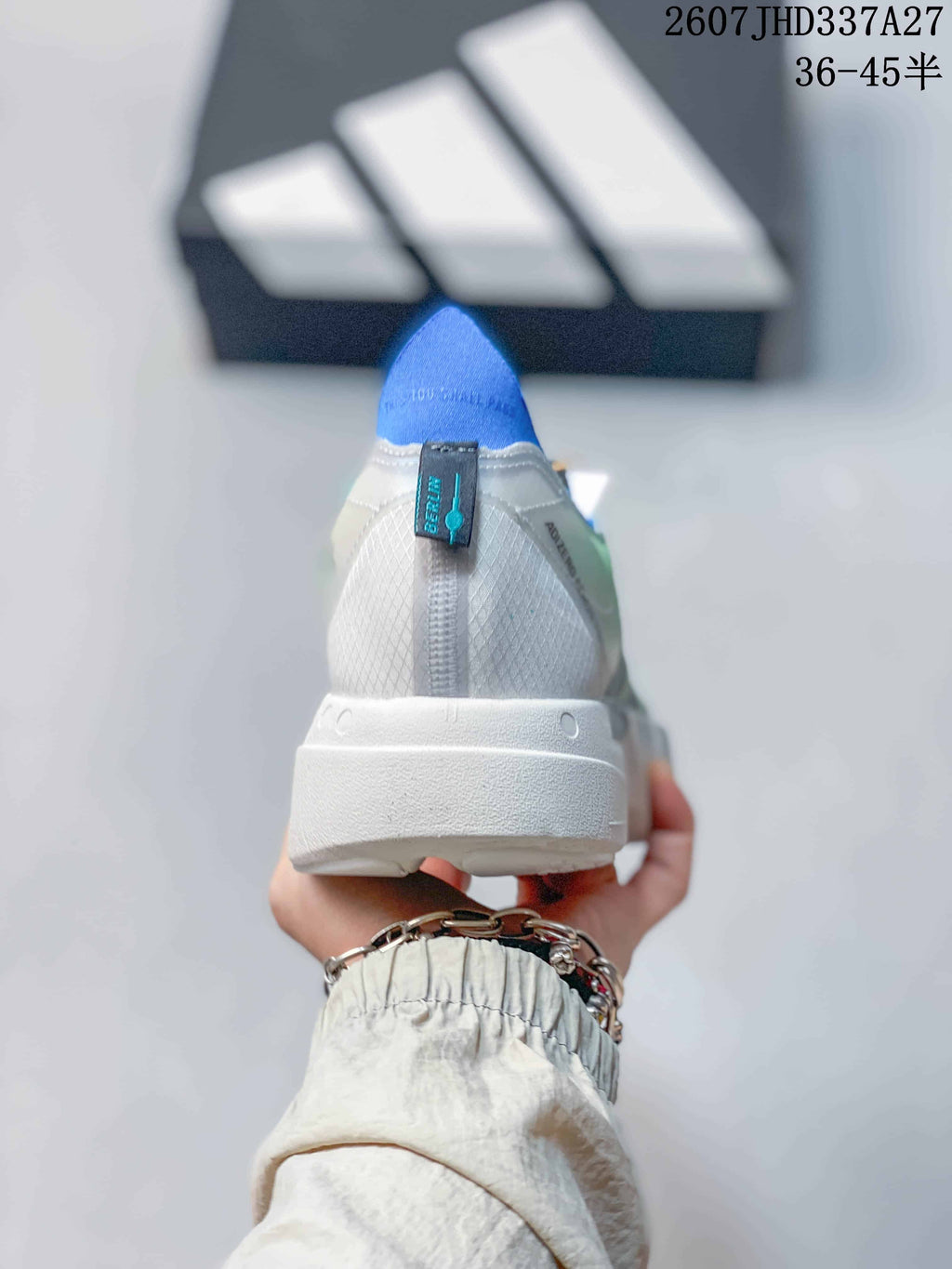 Rear view of the sneaker showing the blue heel collar, white heel panel, and textured white outsole.
