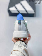 Rear view of the sneaker showing the blue heel collar, white heel panel, and textured white outsole.