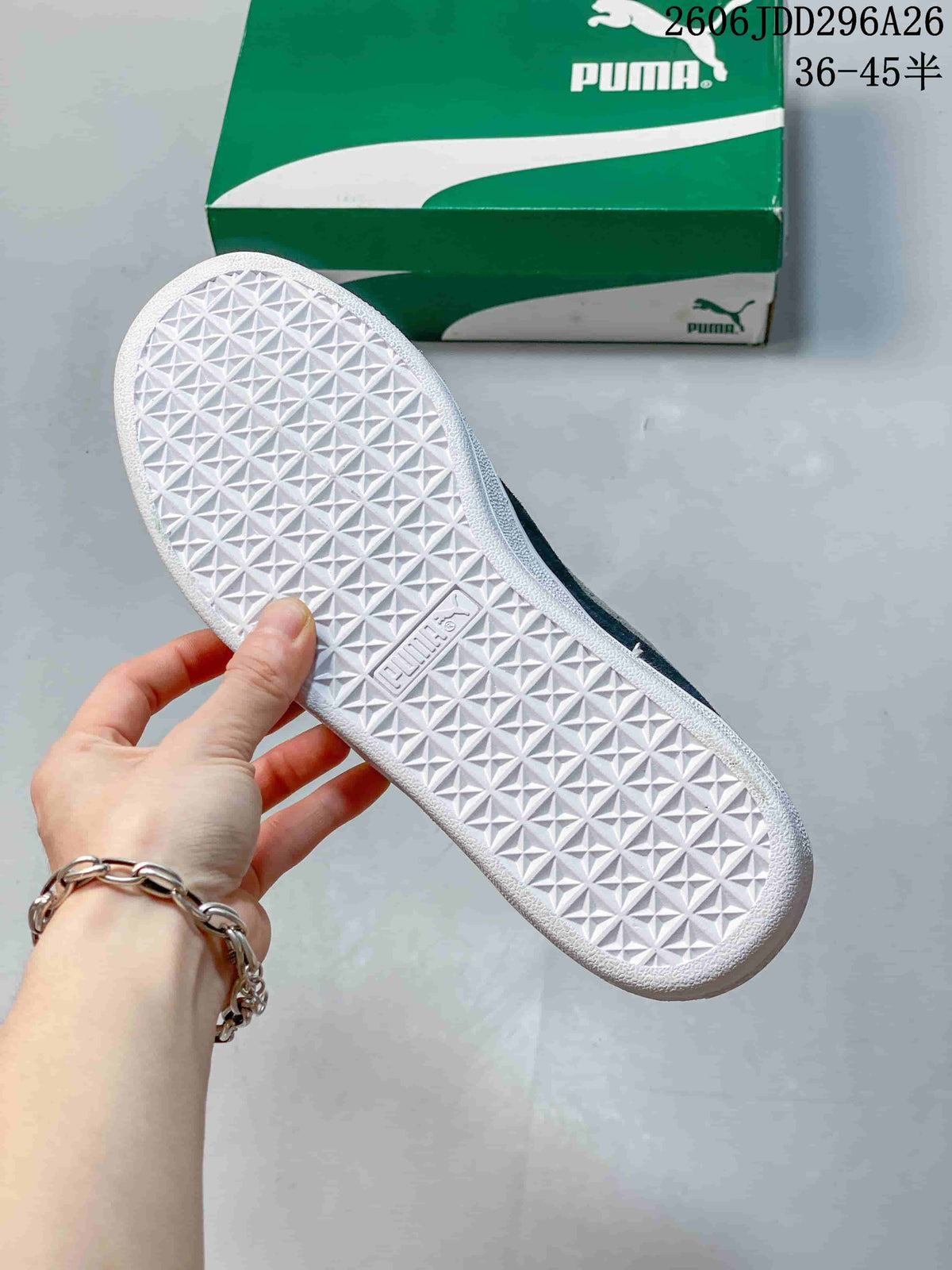 Close view of the white rubber outsole showing a repeating geometric tread pattern and Puma branding, with a green Puma shoe box in the background.