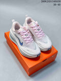 Pair of white and pale pink Nike Vomero Plus running shoes on an orange box.