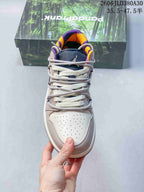 Front view showing the perforated toe, layered laces, and purple and orange collar lining.