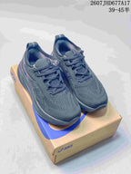 Pair of black ASICS Gel-Nimbus 26 running shoes displayed on an ASICS shoe box; style code 2607JHD677A17 and size range 39–45 are overlaid.