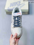 Top view of the white sneaker with blue laces, perforated toe box, and contrasting branding details.