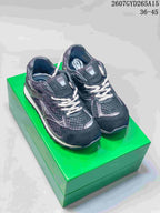 Pair of black and white Bottega Veneta Orbit sneakers displayed on a green box, with the style code and EU size range visible above.