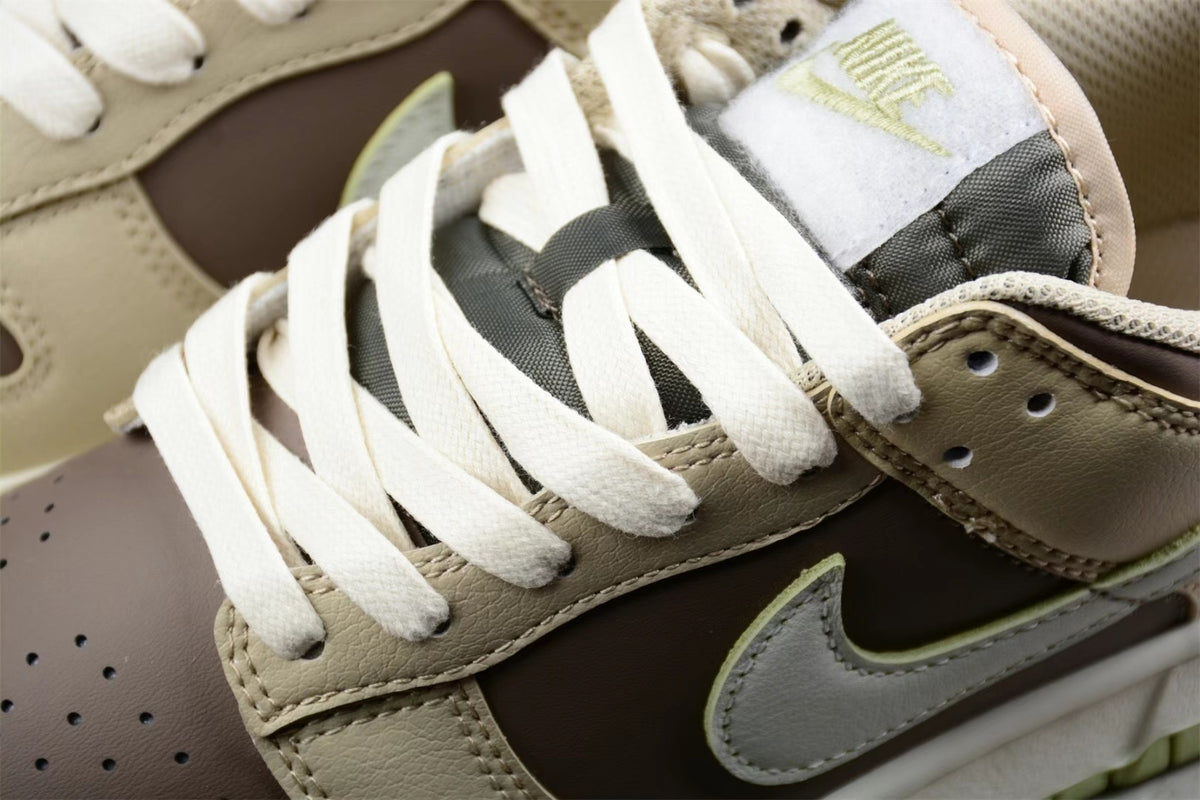 Close-up of the white laces, padded tongue, brown quarter panel, and contrasting Swoosh overlay.