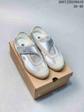 Pair of silver and white DESCENTE low-top sneakers displayed on a shoebox.