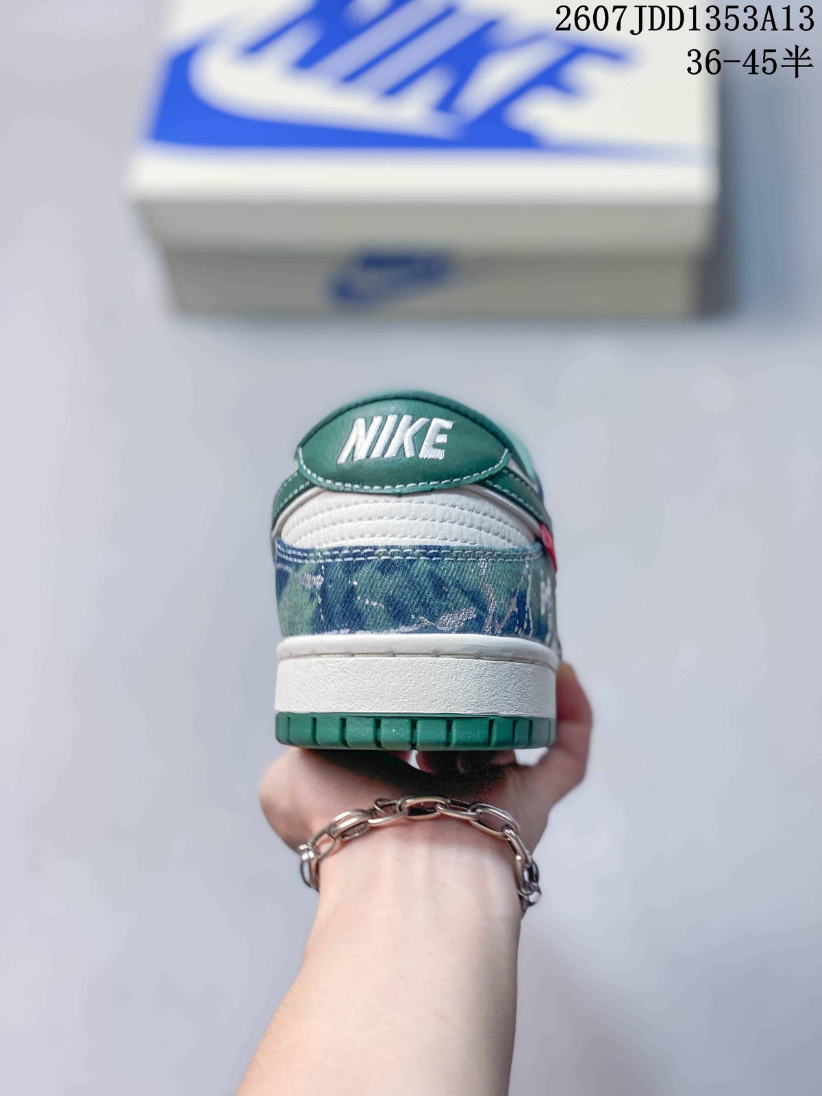 Rear view showing the green heel tab, white midsole, patterned blue heel panel and green outsole.