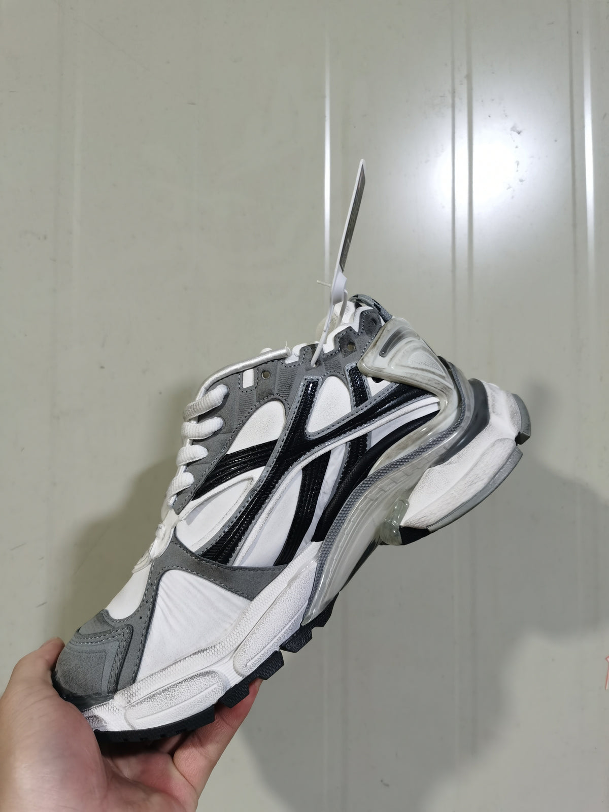 Angled close-up of a grey, white, and black Puma 9012 Runner sneaker showing layered side panels and a sculpted outsole.