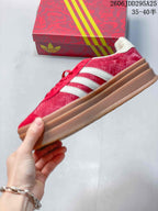 Side profile of the red sneaker showing white stripes and a layered gum-colored platform sole.