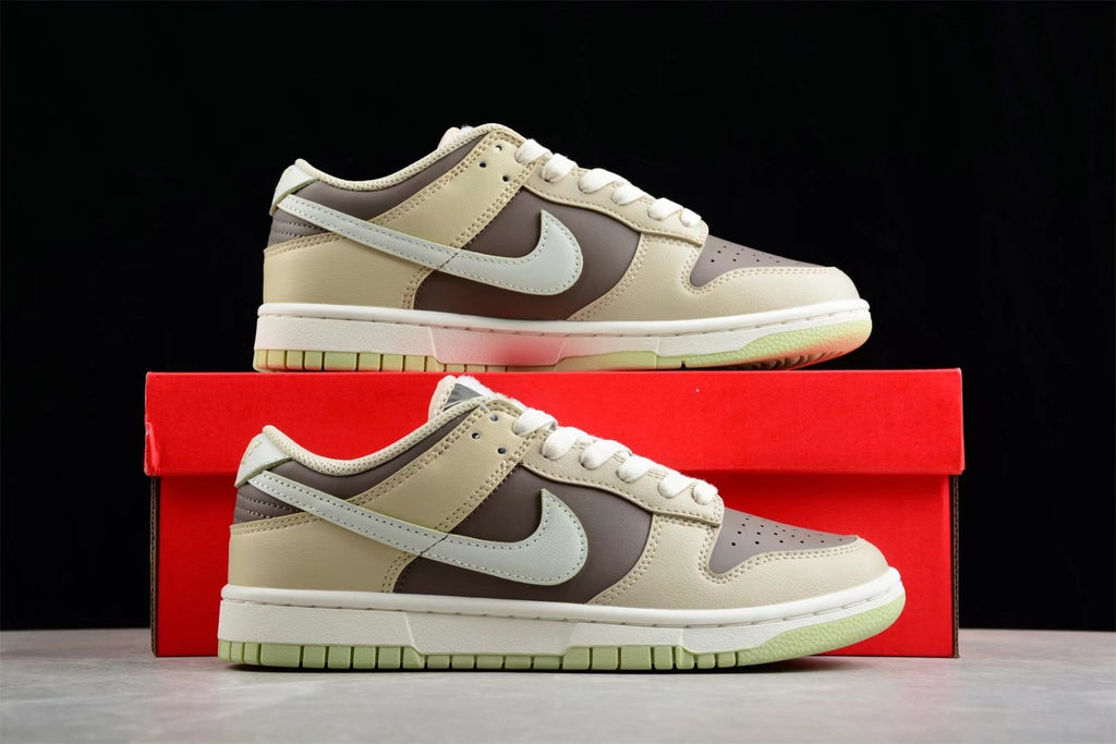 Side profile of the sneakers displayed above a red shoebox, highlighting the beige, brown, and light green color scheme.