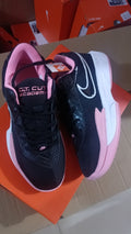 Black Nike Court Academy sneakers with pink accents and a white-and-pink sole, photographed from above