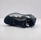 Top-down side view showing the black upper, lace area, tongue branding and graffiti panel.