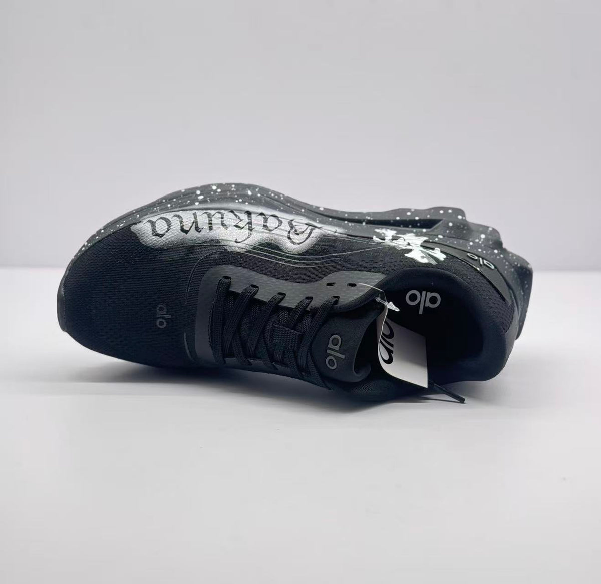 Top-down side view showing the black upper, lace area, tongue branding and graffiti panel.
