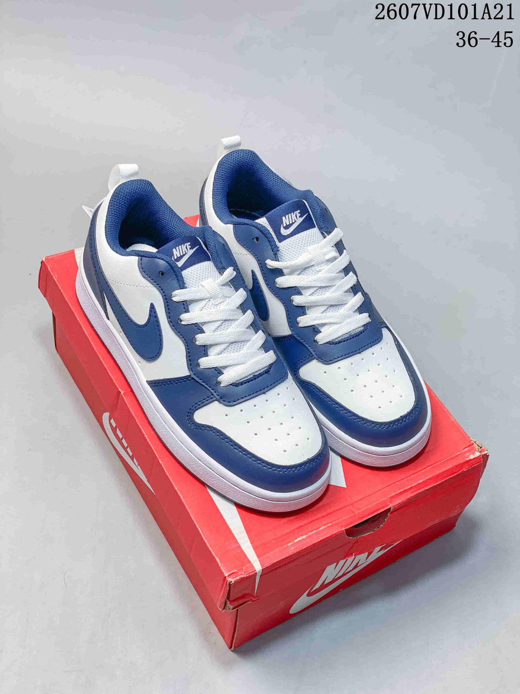 Blue and white Nike Court Borough Mid BG sneakers displayed on a red shoebox, with the visible code 2607VD101A21 and size range 36–45.