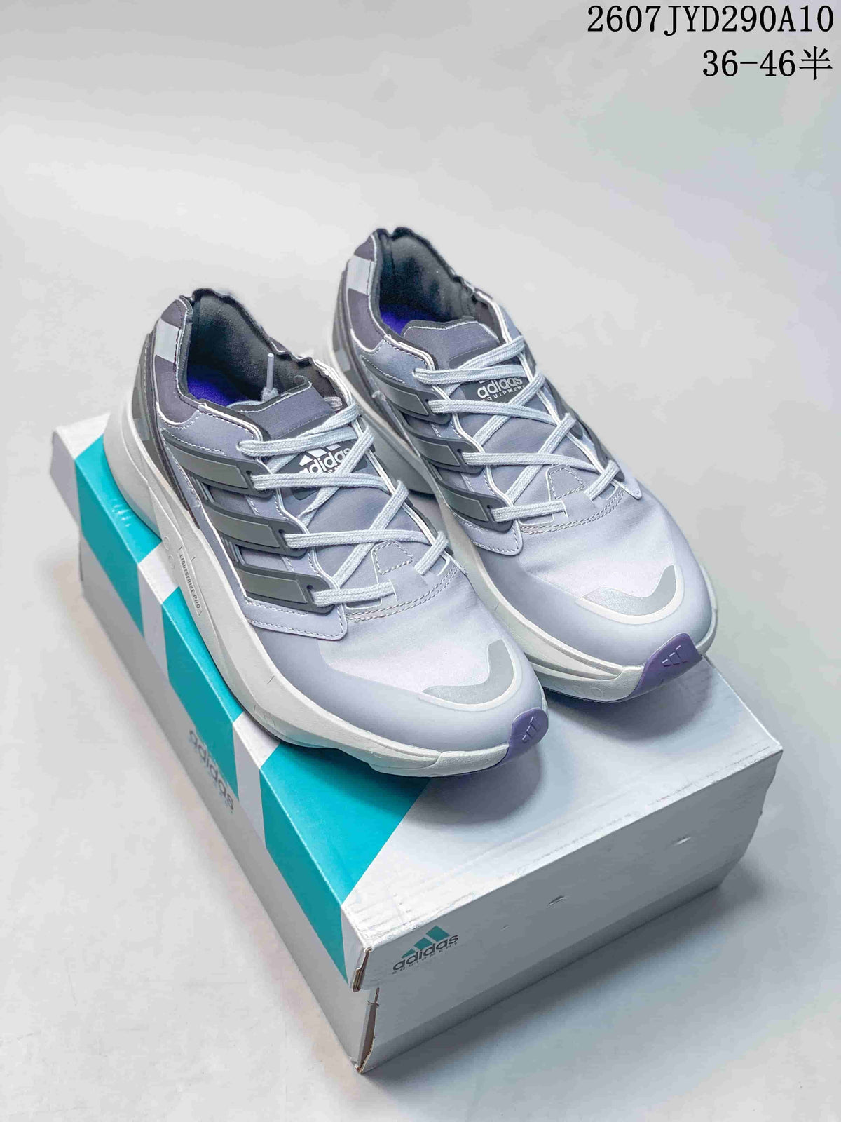 Pair of gray adidas Equipment Adios Pro sneakers displayed on an adidas shoe box.